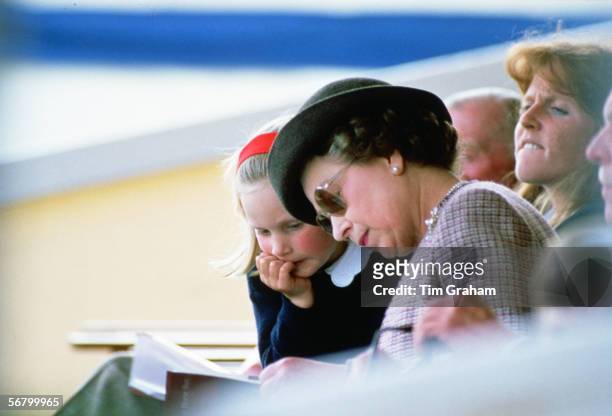 Queen Elizabeth II reading with her granddaugter Zara Phillips at Windsor Horse Show.
