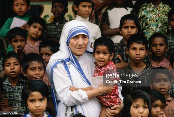 Mother Teresa accompanied by children at her mission in Calcutta, India.