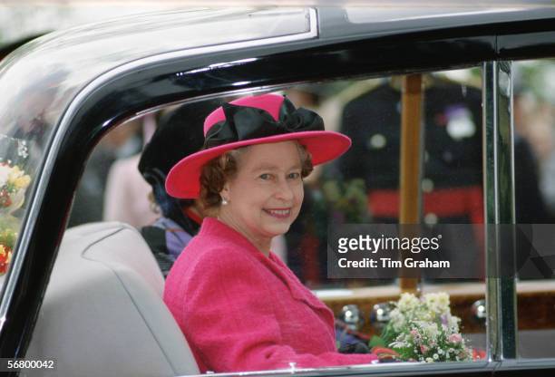 Queen Elizabeth II in her Rolls Royce car during a visit to Wales. The Queen is wearing a hat designed by milliner Frederick Fox.