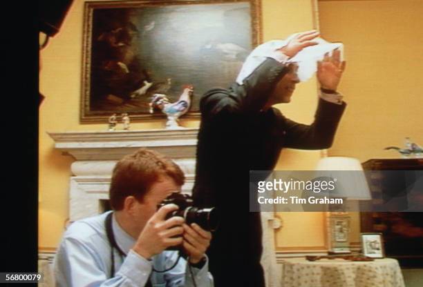 Prince Charles tries to get the attention of Princes William and Harry while photographer Tim Graham photographs them at Kensington Palace.