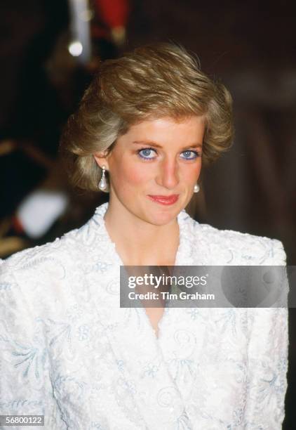 Diana, Princess of Wales, wearing a white and blue lace and sequin evening coat-dress designed by Catherine Walker for a dinner at the Chateau de...