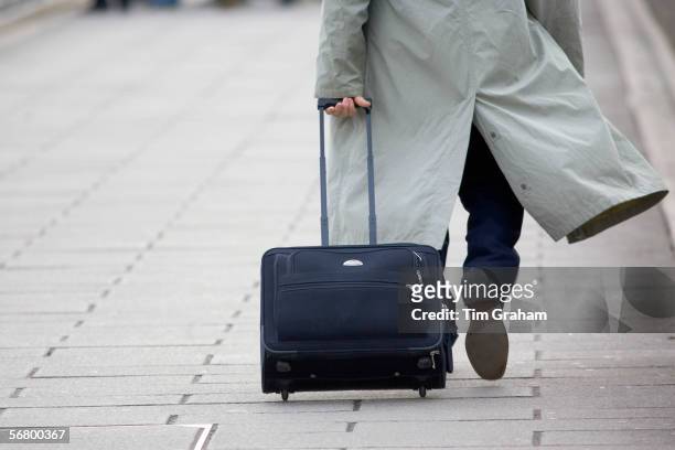 Commuter pulling a suitcase, London, England, United Kingdom.