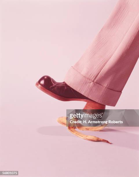 1970s: Person wearing stack heeled shoes and bell bottoms, about to step on a banana skin.