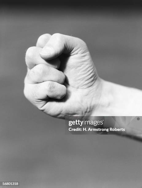 1930s: Man's hand making fist.