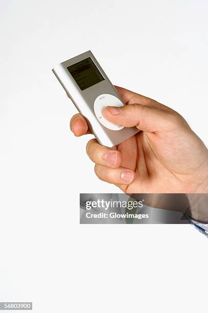 close-up of a person's hand holding an mp3 player - mp3 player stock pictures, royalty-free photos & images