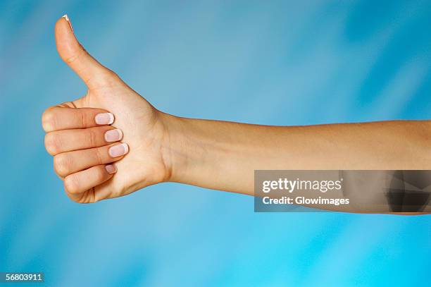 close-up of a woman's hand making a thumbs up sign - woman thumb stock pictures, royalty-free photos & images