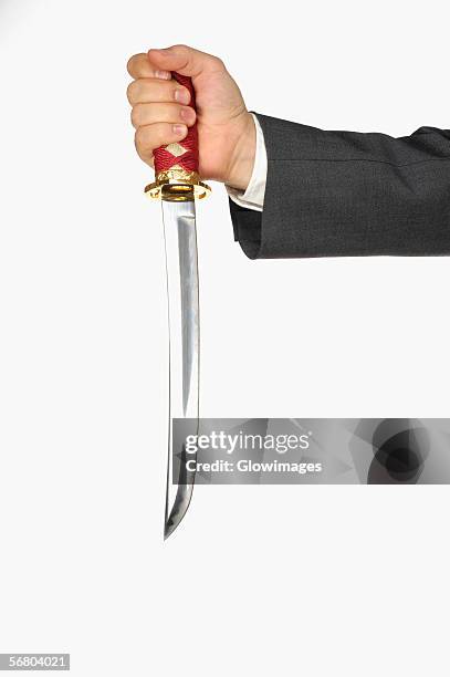 close-up of a businessman holding a sword - holding sword stock pictures, royalty-free photos & images