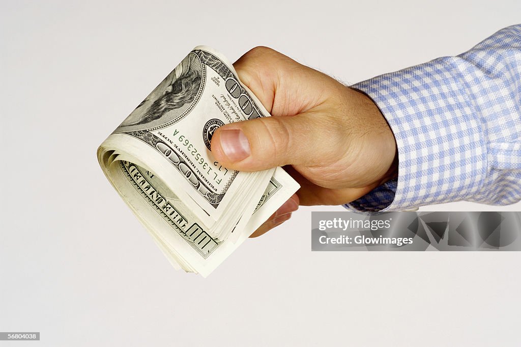 Close-up of a person's hand holding paper currency