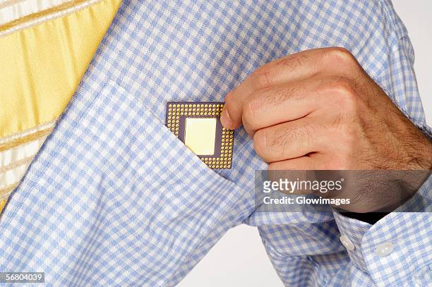 mid section view of a businessman putting a computer chip into his shirt pocket - shirt pocket stock pictures, royalty-free photos & images