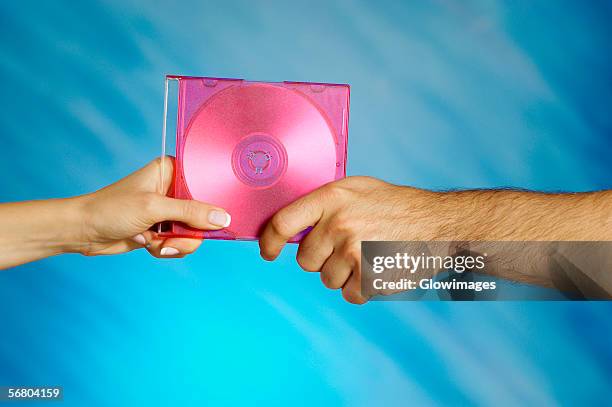 close-up of a man and a woman's hands holding a compact disk - cd case stock pictures, royalty-free photos & images