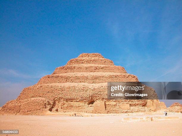 pyramid in an arid landscape, the step pyramid of zoser, saqqara, egypt - saqqara foto e immagini stock