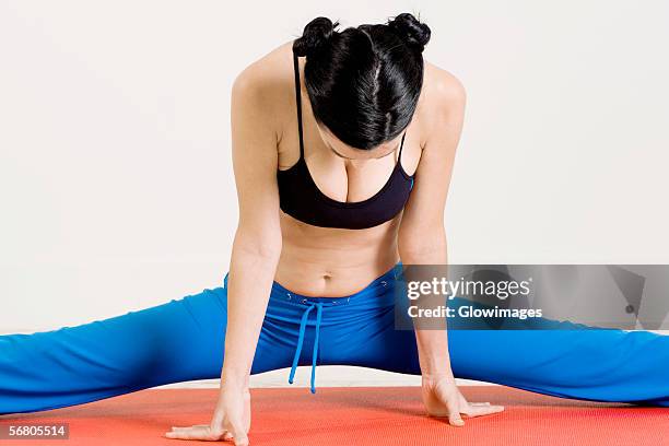 close-up of a young woman stretching on an exercising mat - dekolleté stock-fotos und bilder