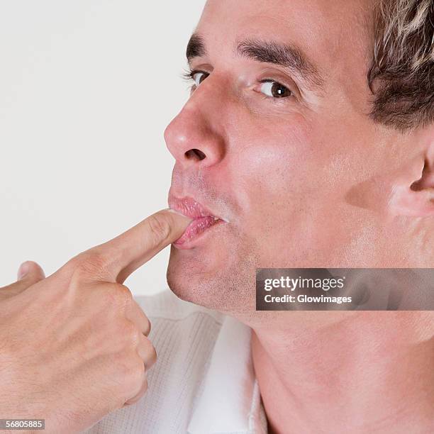 close-up of a mid adult man licking his finger - finger in mouth fotografías e imágenes de stock