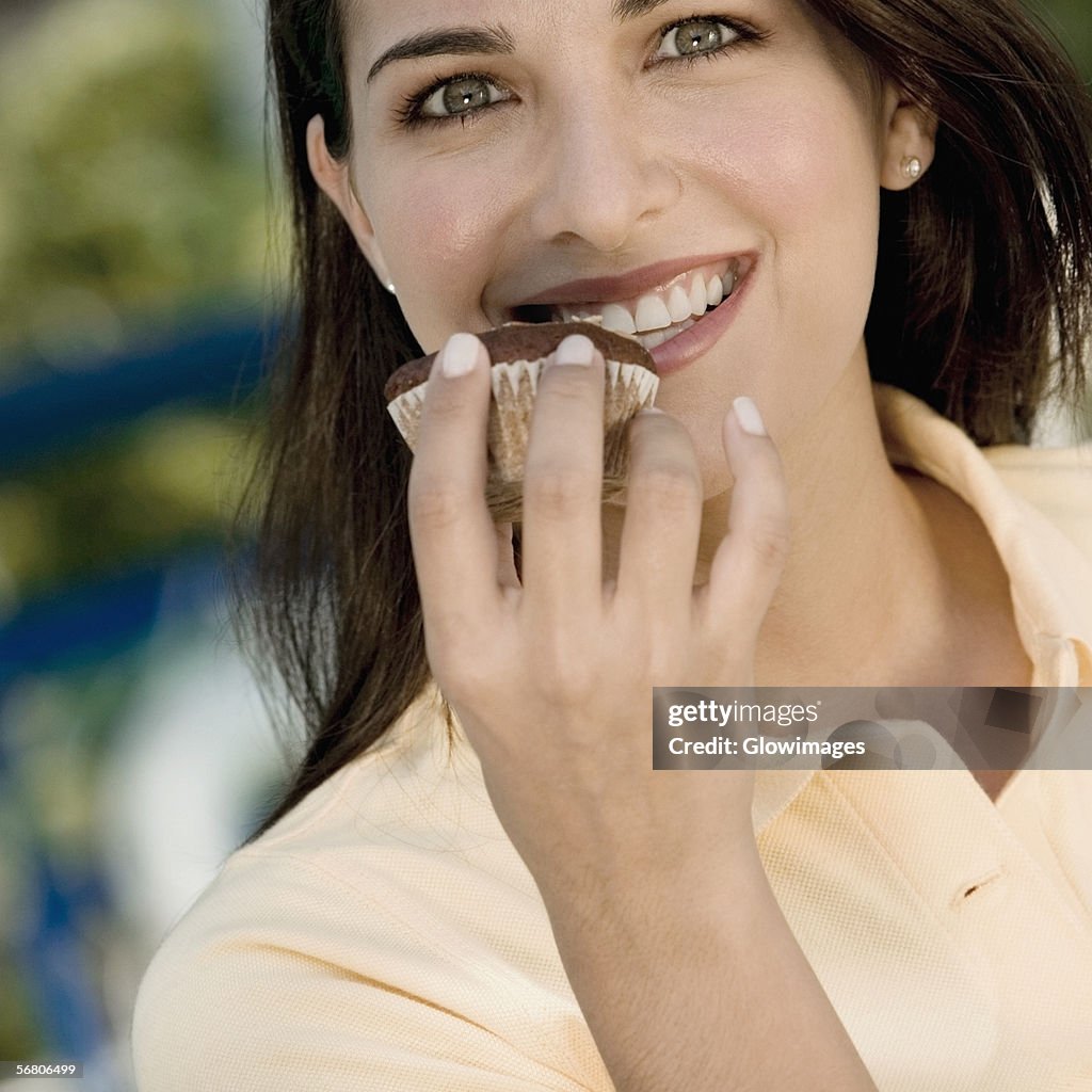 Portrait of a young woman holding a muffin