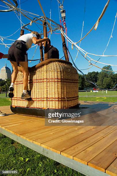 close-up of a woman climbing into a hot air balloon basket, boston, massachusetts, usa - hot air balloon basket stock pictures, royalty-free photos & images