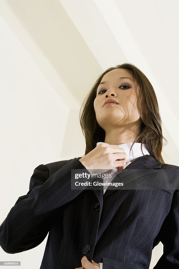 Low angle view of a businesswoman adjusting her tie