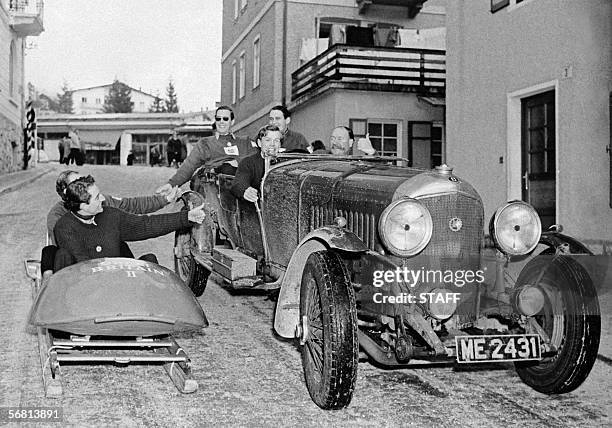 Cortina d'Ampezzo, ITALY: File photo shows the British two-man bobsleigh team greeting passengers riding in a Bentley 25 February 1956 in the streets...