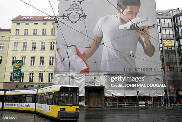 Picture taken 04 December 2005 shows a tram driving past a giant billboard advertising a sports shoe shop featuring a man sniffing a Puma shoe in...