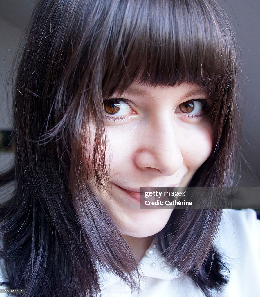 Pretty female with dark, sleek hair and fringe