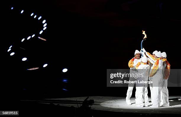 Alberto Tomba, Silvio Fauner, Marco Albarello, Maurilio de Zolt and Giorgio Vanzetta hold the Olympic flame during the Opening Ceremony of the Turin...