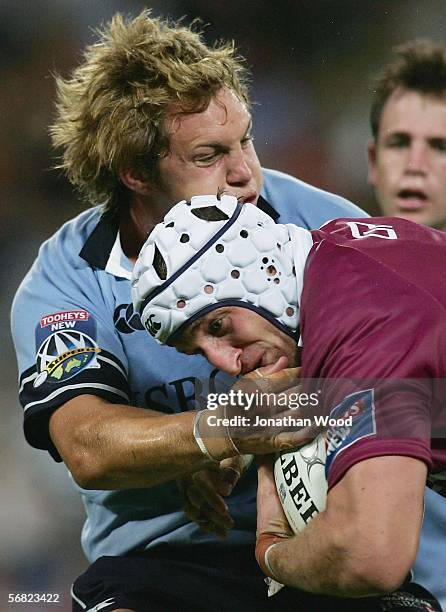 Mark Connors of the Reds is tackled by a Waratahs opponent during the round one Super 14 match between the Queensland Reds and Waratahs at Suncorp...