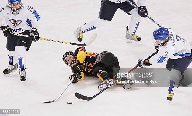 Emma Laaksonen and Mari Pehkonen of Finland attempt to take posession of the puck from Nikola Holmes of Germany in the third period during their...