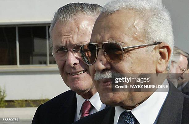 Algerian Defence Minister Abdelmalek Guenaizia escorts US Defence Secretary Donald Rumsfeld during their meeting in Algiers 12 February 2006. The...