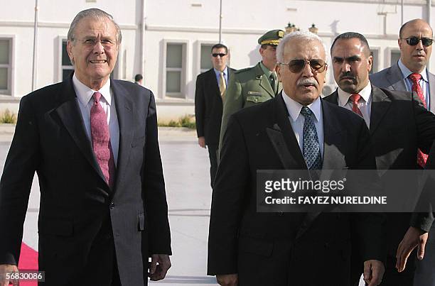 Algerian Defence Minister Abdelmalek Guenaizia escorts US Defence Secretary Donald Rumsfeld during their meeting in Algiers 12 February 2006. The...