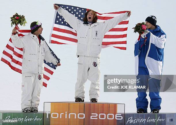 Halfpipe snowboarder Shaun White celebrateson the podium next to second place US Daniel Kass and Finland's Markku Koski after winning the Men's...