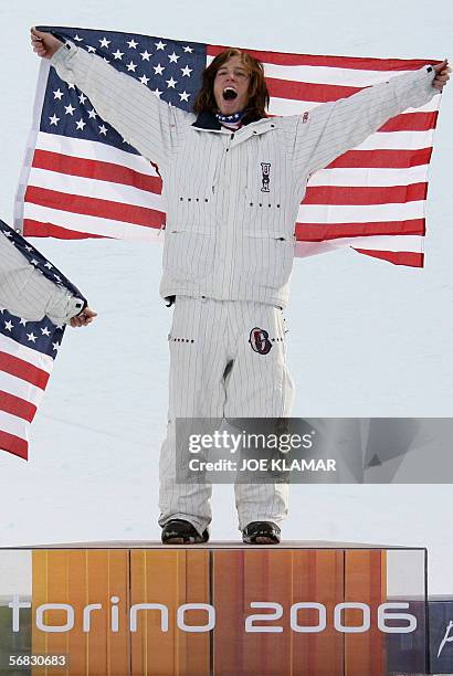 Halfpipe snowboarder Shaun White celebrates on the podium after winning the Men's snowboard Halfpipe finals on the second day of the Turin 2006...