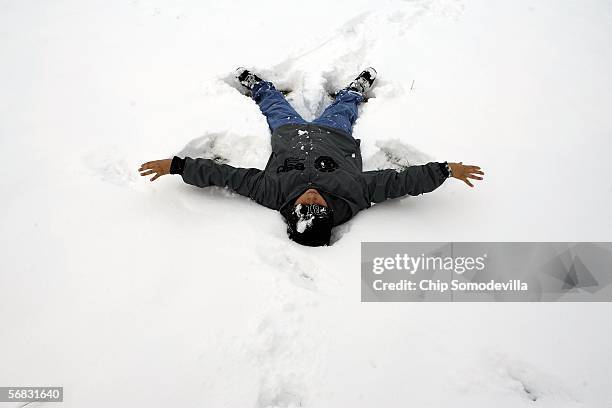 Eleven-year-old Caleb Sandoval of Mililani, Hawaii, makes a snow angel in Laffayette Square across the street from the White House February 12, 2006...