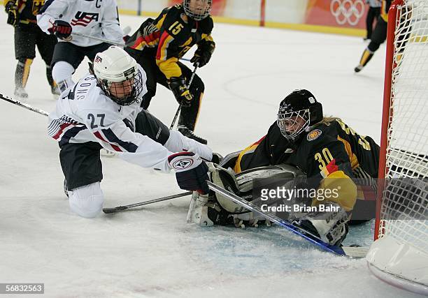 Sarah Parsons of the United States slips the puck past goalie Jennifer Harss of Germany to score the team's fifth goal of the game in the third...