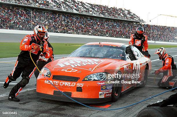 Members of the pit crew of Tony Stewart's Home Depot Chevrolet change out four tires during NASCAR Nextel Cup Budweiser Shootout on February 12, 2006...