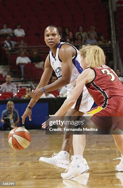 Elaine Powell of the Orlando Miracle looks to pass around Debbie Black of the Miami Sol during the preseason game at TD Waterhouse Centre in Orlando,...