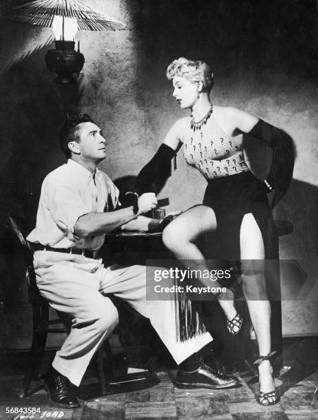 American actress Shelley Winters , with Macdonald Carey in a scene from 'South Sea Sinner, directed by H. Bruce Humberstone, 1950. Winters is wearing...