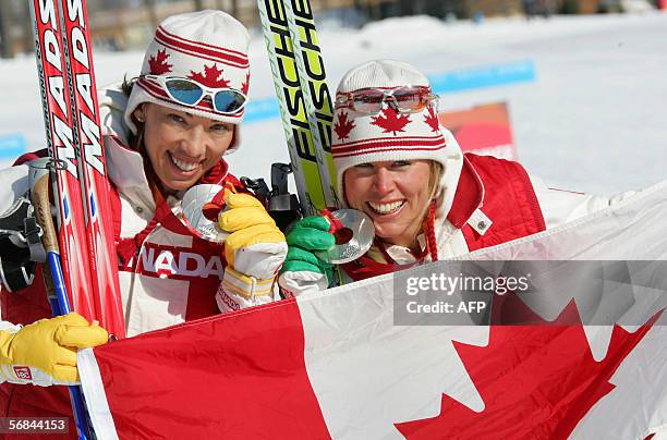 Canada's Beckie Scott and Sara Renner display their medals after the women team sprint final of the 2006 Winter Olympics in Pragelato, 14 February...