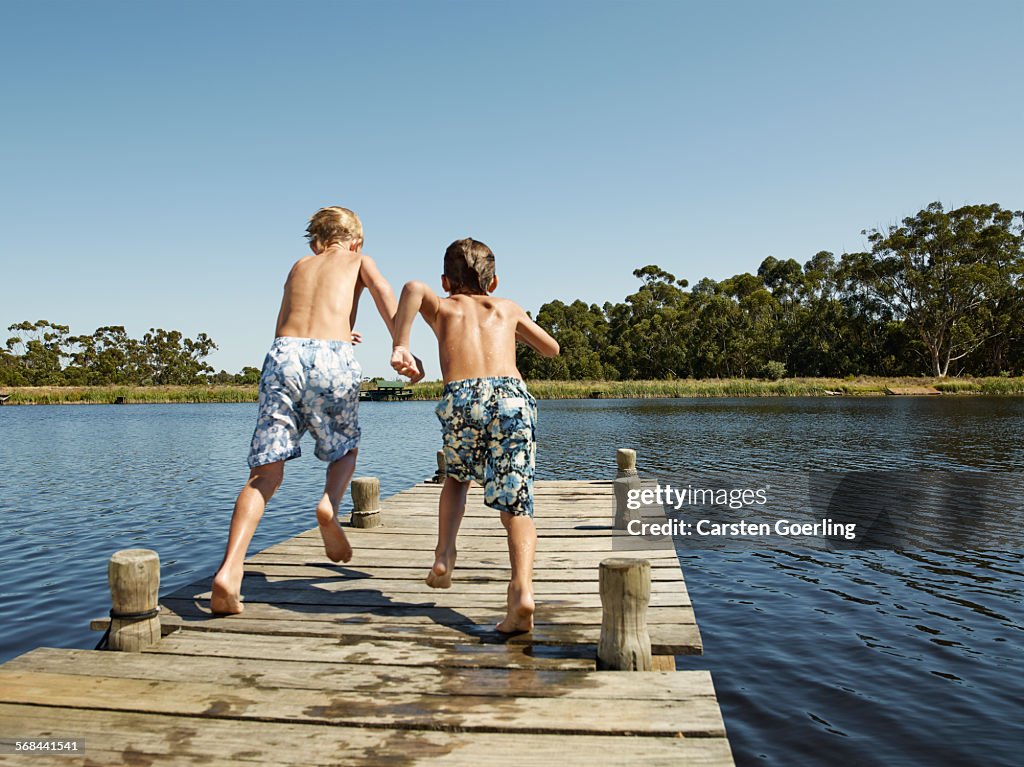 2 boys running on a jetty