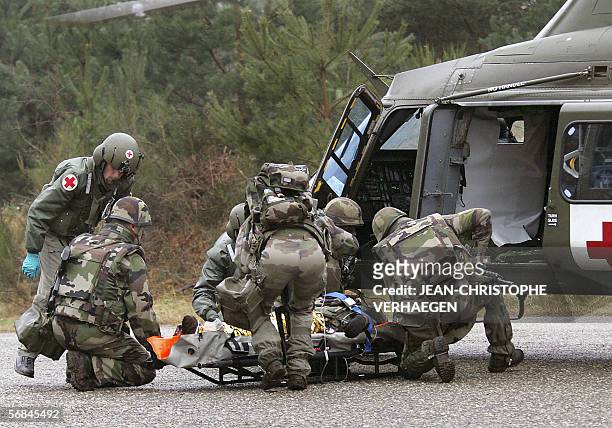 French soldiers carry out a man supposed to be injured on a stretcher to an emergency helicopter during the Brilliant Ledger Exercise, under command...