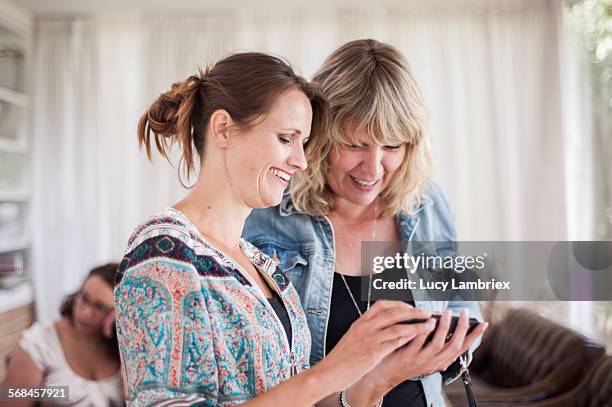 women looking at the smartphone photos they took - showing appreciation stock pictures, royalty-free photos & images