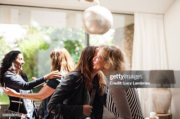 women greeting one another - kissing stockfoto's en -beelden