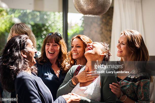 women at reunion greeting and smiling - lachen stock-fotos und bilder