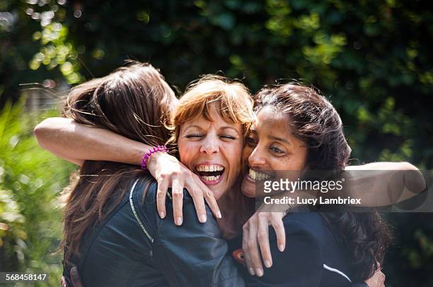 women greeting one another - abbracciare una persona foto e immagini stock