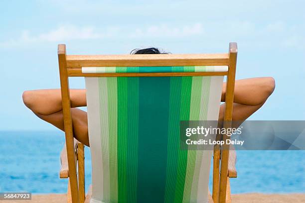 woman lying in deckchair, rear view - man on the beach relaxing in deckchair fotografías e imágenes de stock