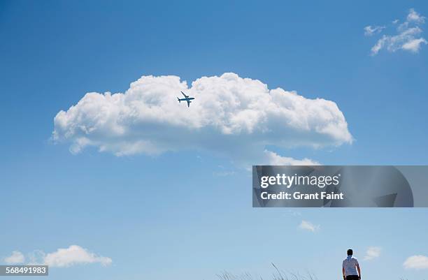 mman watching jet in flight - thinking man cloud stockfoto's en -beelden