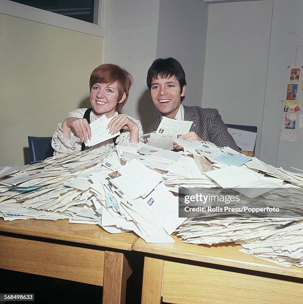 English pop singers Cilla Black and Cliff Richard helping to count the votes from BBC television viewers for 'A Song For Europe', the British...