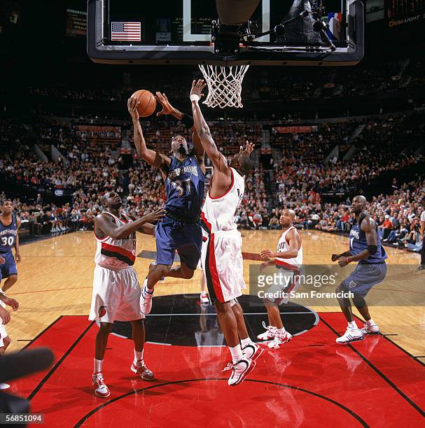 Ricky Davis of the Minnesota Timberwolves takes the ball to the basket between Zach Randolph and Theo Ratliff of the Portland Trail Blazers during a...