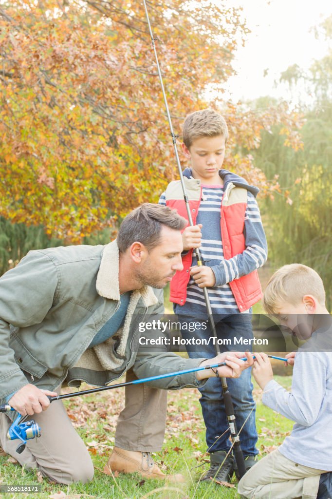 Father teaching sons to prepare fishing rods