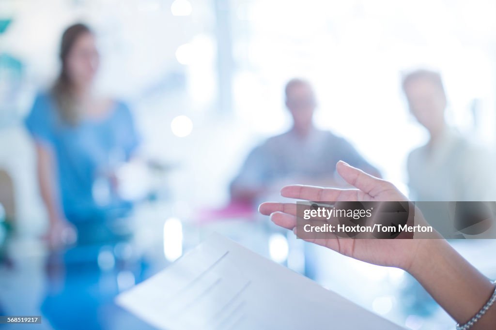 Close up of businesswomans hand gesturing to paperwork in meeting