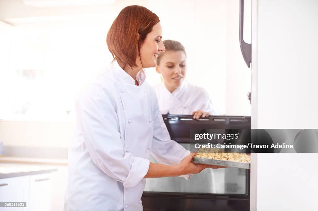 Chefs colocando la bandeja en el horno