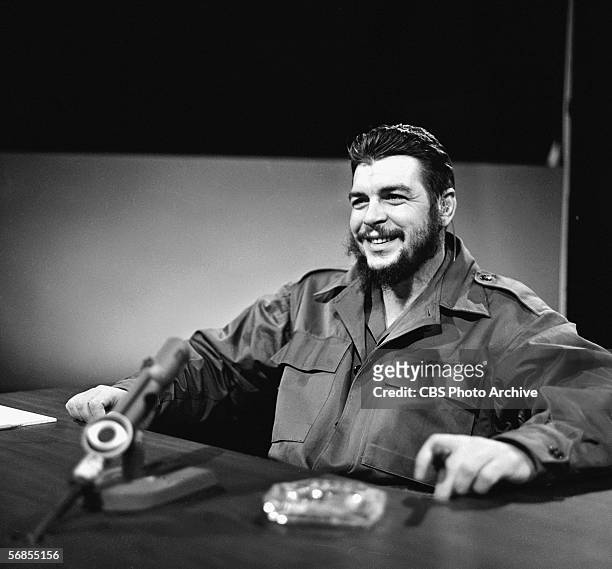 Argentinian-born Marxist revolutionary Ernesto Che Guevara , Cuban Minister of Industry, dressed in military fatigues, smiles and smokes a cigar as...
